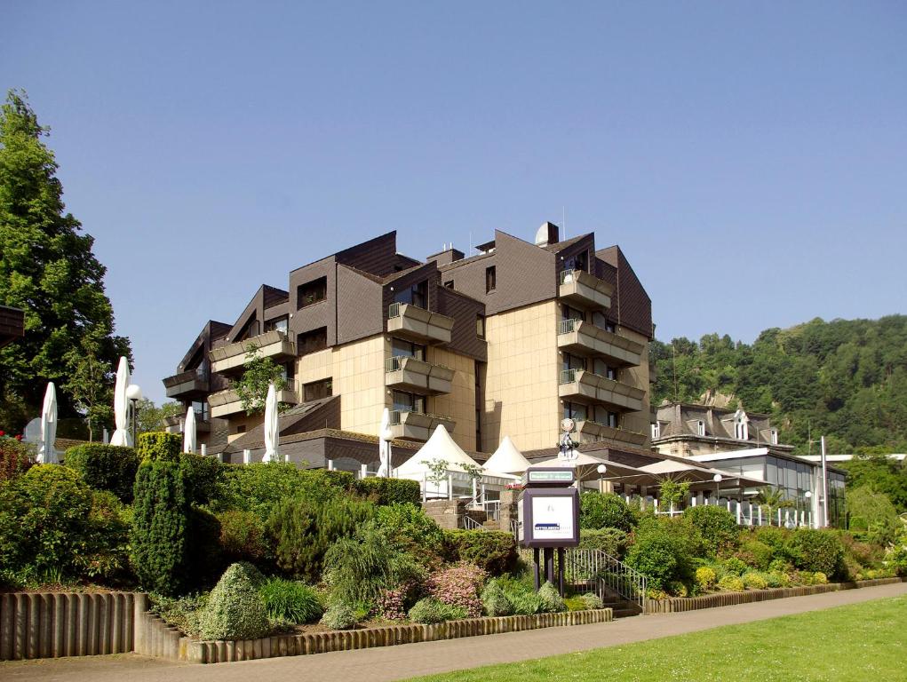 un gran edificio se muestra frente a un jardín en Parkhotel "Am Schänzchen", en Andernach