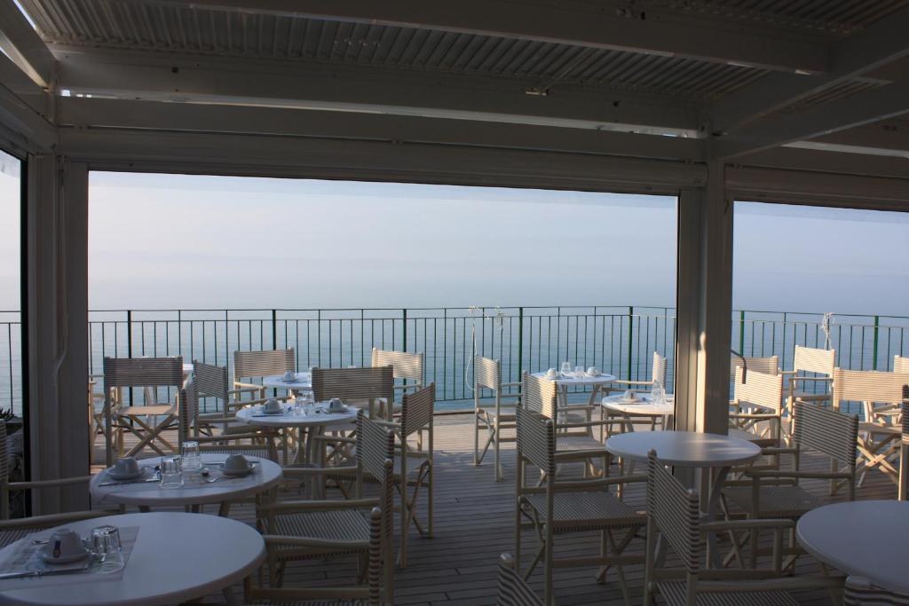 
a dining area with tables, chairs and umbrellas at Hotel Gianni Franzi in Vernazza
