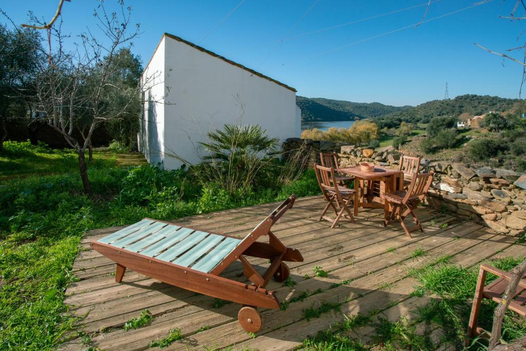 um deque de madeira com uma mesa e cadeiras em Casa de las Letrinas Baja, 2 Habt 5 más 1 Pers max chimenea con horno em Puerto de la Laja