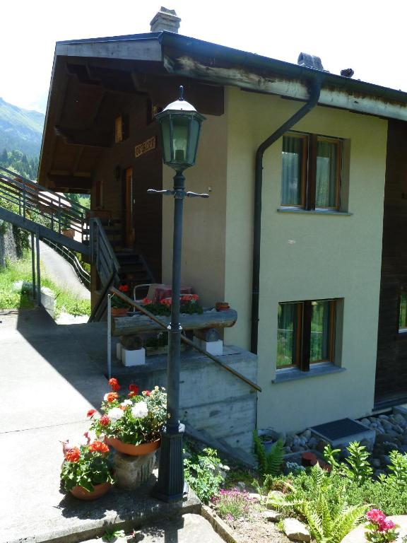 a street light in front of a house with flowers at Chalet Gerbera in Wengen