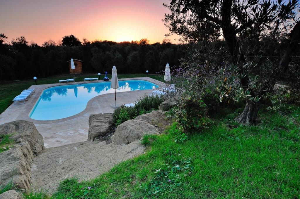 une piscine avec vue sur le coucher du soleil en arrière-plan dans l'établissement Cerchio Verde, à Pitigliano