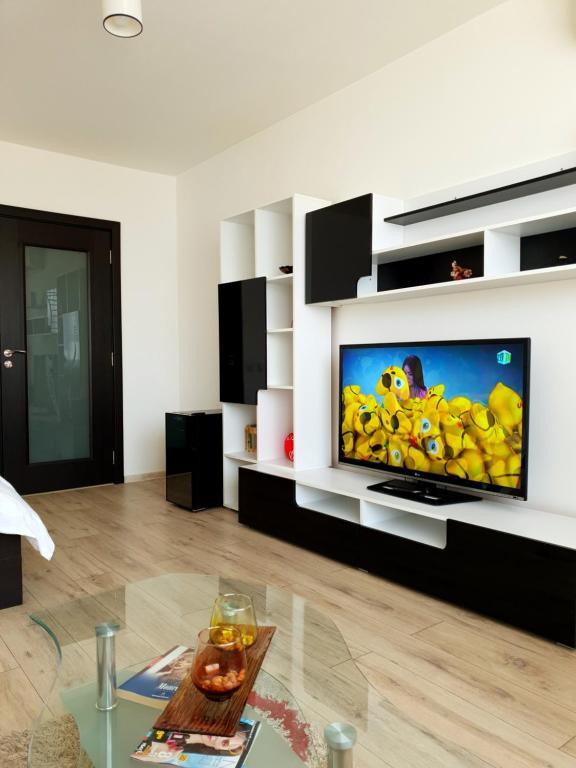a living room with a large flat screen tv on a wall at Studio Central in Piatra Neamţ