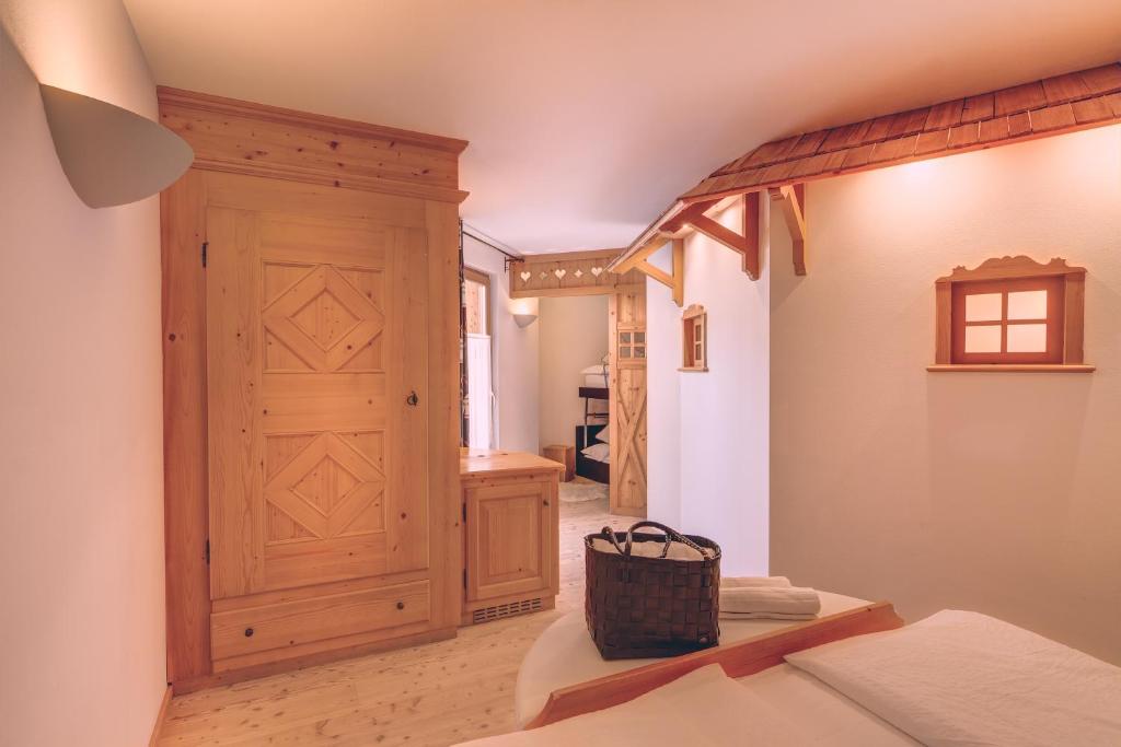 1 dormitorio con puerta de madera y pasillo en Hotel Madonnina Resort And Wellness, en Soraga