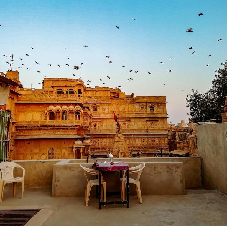 un grupo de aves volando sobre un edificio en Hotel Mirage en Jaisalmer