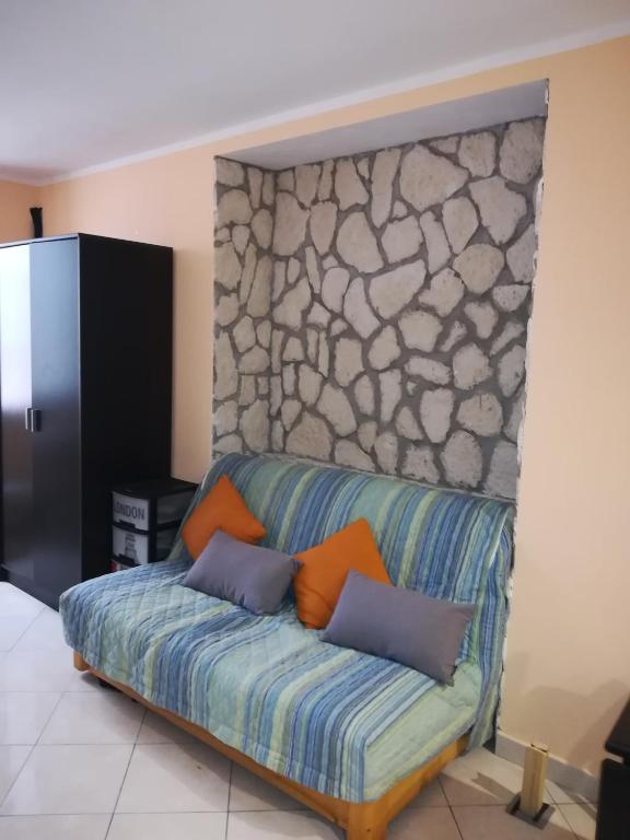 a couch in a room with a stone wall at Le Malte in Menton