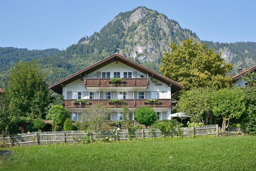 a house with a fence in front of a mountain at Haus Katrin in Bad Hindelang