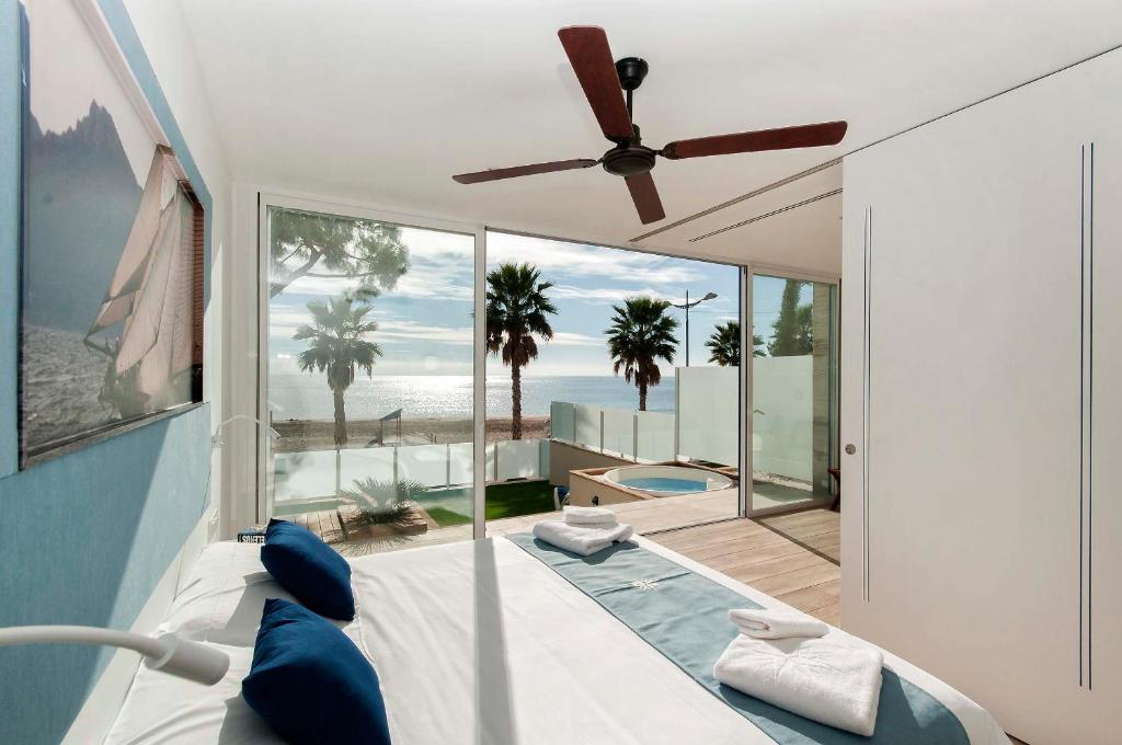 a bedroom with a bed and a ceiling fan at Suites at Sea in Villajoyosa