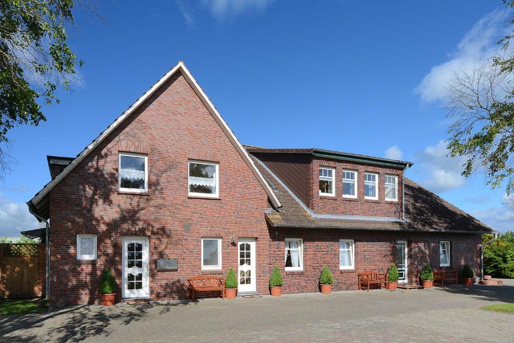 a large brick house with chairs in front of it at Hof Lueck in Esens