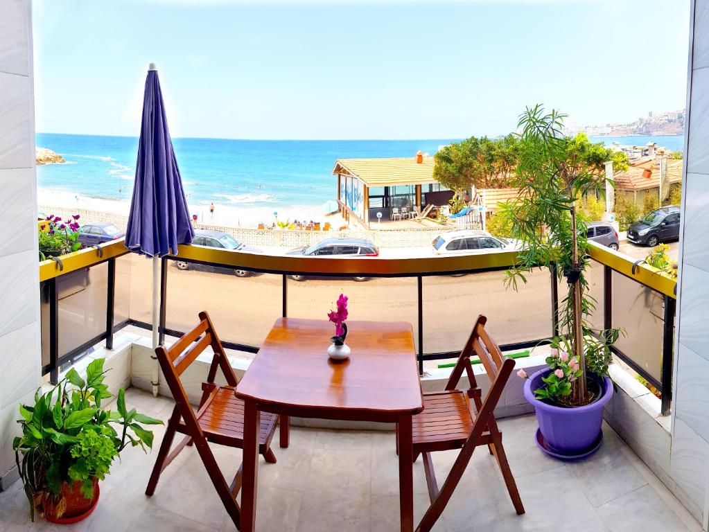 un tavolo e sedie su un balcone con vista sulla spiaggia di AlSaeed Residence a Jounieh