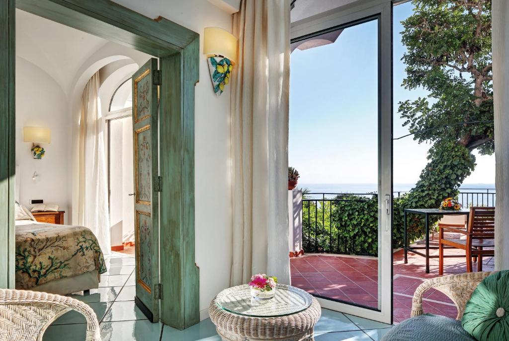 a room with a door to a balcony with a view of the ocean at Hotel Santa Caterina in Amalfi