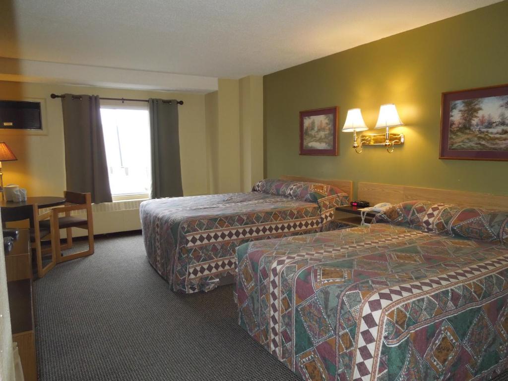 Una cama o camas en una habitación de Walking Eagle Inn & Lodge