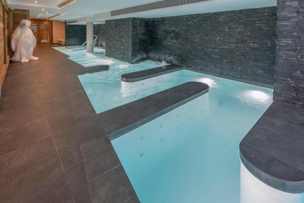 a swimming pool with blue lights in a building at Le Kaïla in Méribel