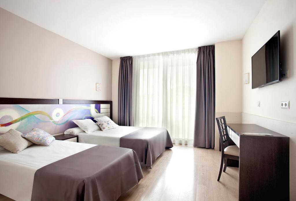A bed or beds in a room at Hotel Indalo Park