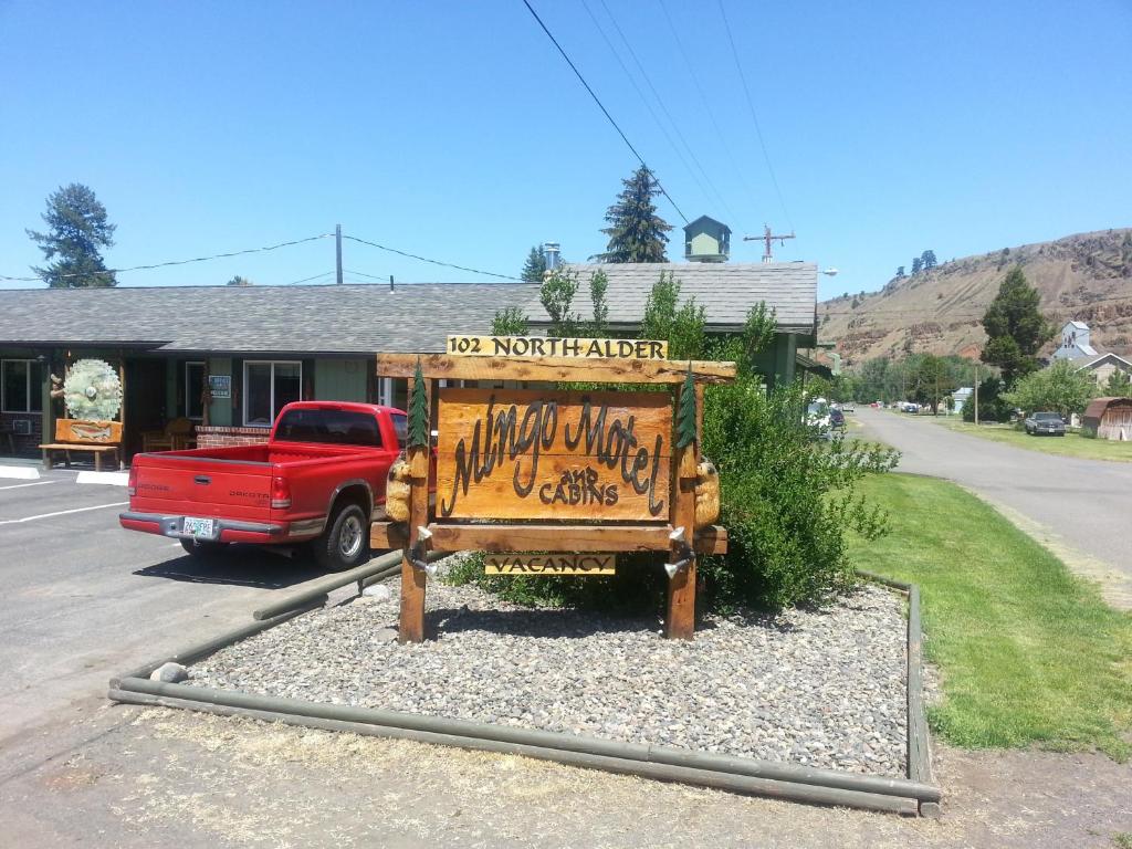 a red truck parked in front of a no north stranger sign at Mingo Motel in Wallowa