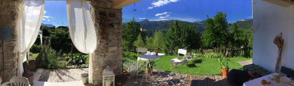een uitzicht op een tuin met een tafel en stoelen bij Villa Monica in Brentonico