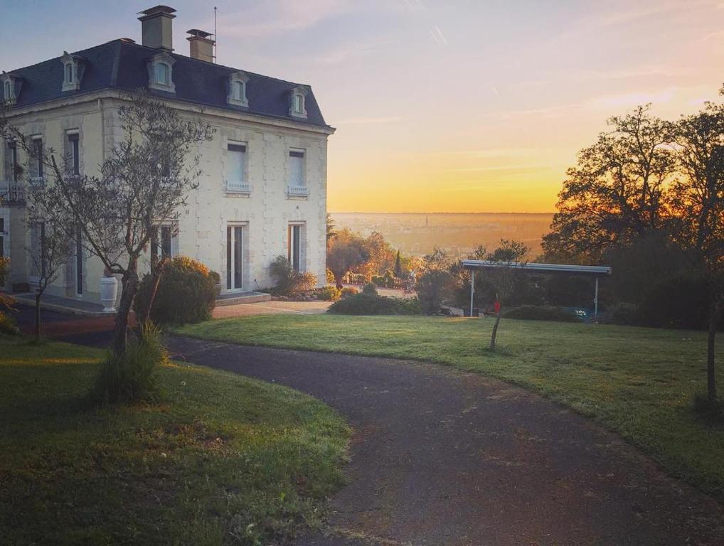 una casa en una colina con la puesta de sol en el fondo en Château Ollé Laprune, en Jurançon