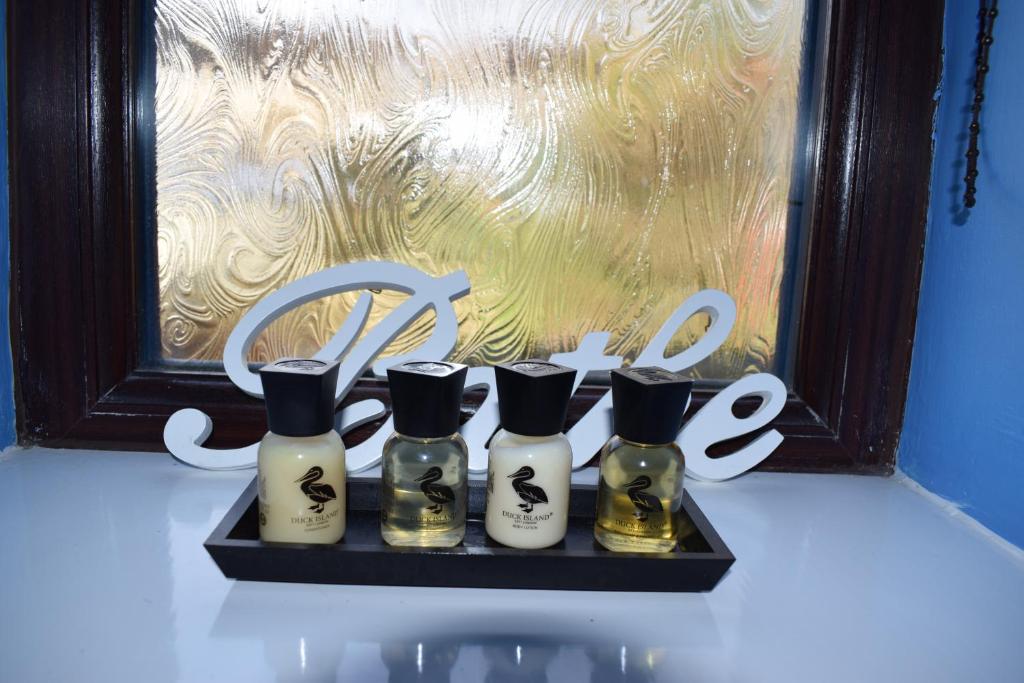 a shelf with four bottles of perfume in front of a window at Castle Green Bed and Breakfast in Matlock