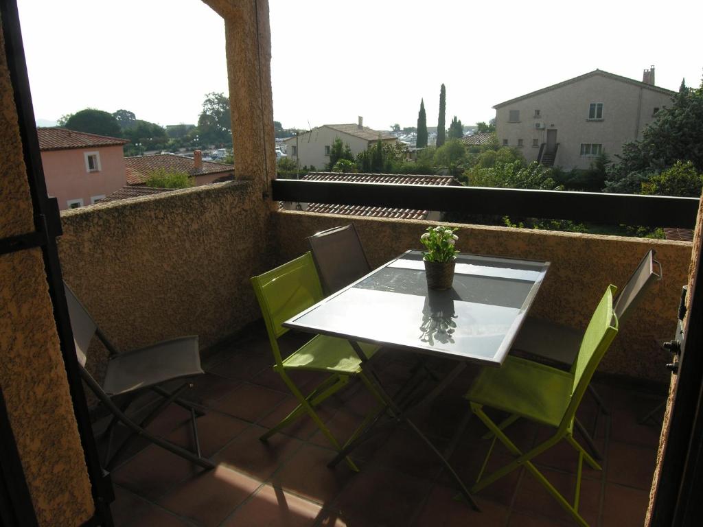 a table and chairs on a balcony with a view at Studio Mezzanine vue port et mer in La Londe-les-Maures