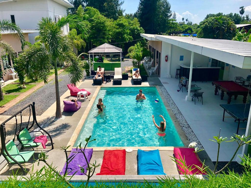 a swimming pool with people in a backyard at Samui Backpacker Hotel in Bangrak Beach