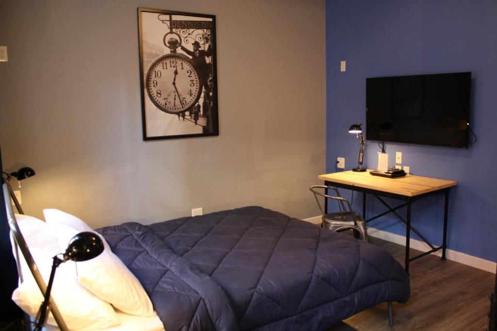 a bedroom with a bed and a table with a clock on the wall at Apple Hostels of Philadelphia in Philadelphia