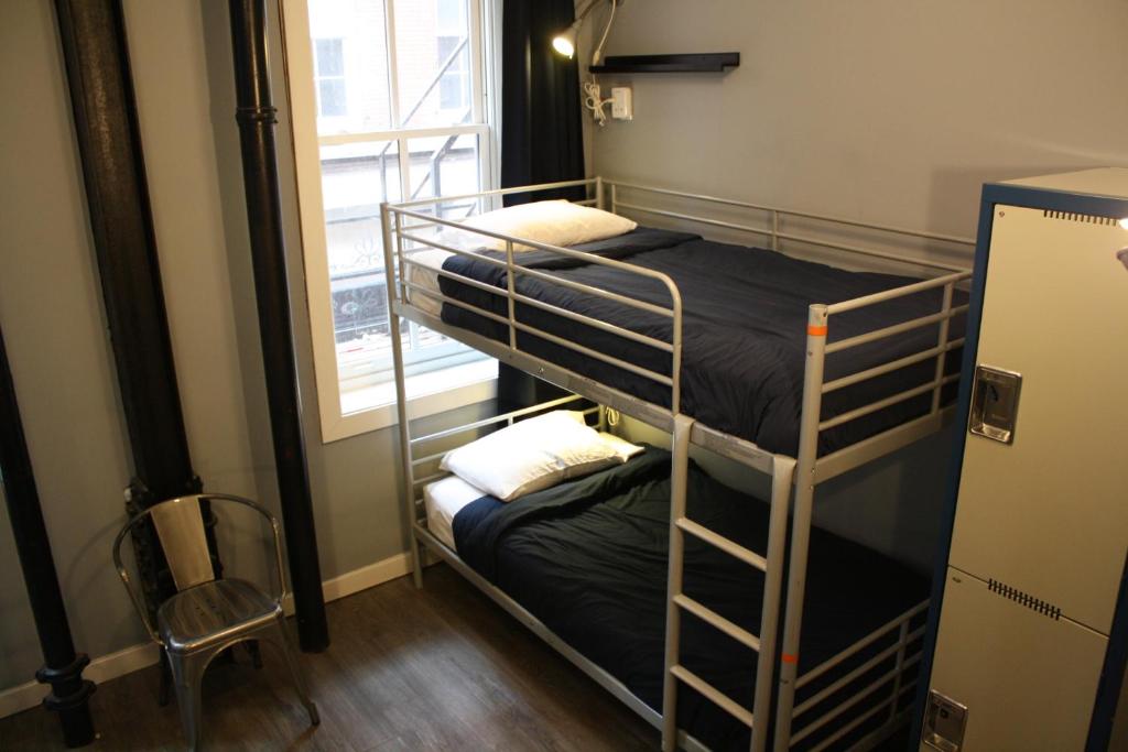 two bunk beds in a room with a window at Apple Hostels of Philadelphia in Philadelphia