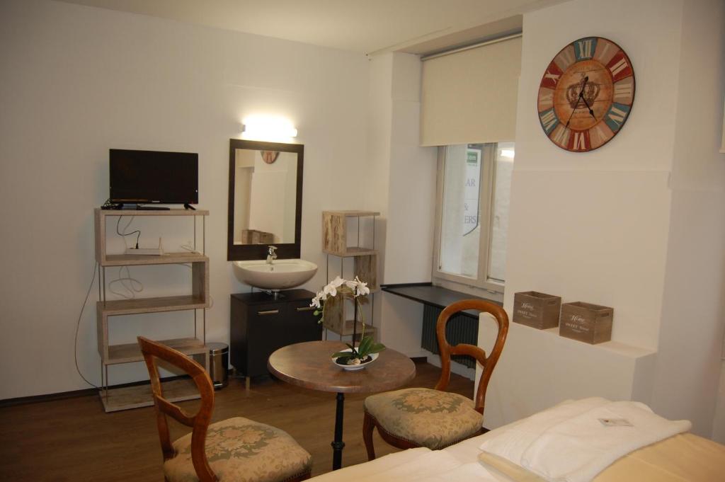 Zimmer mit einem Bett, einem Tisch und einer Uhr in der Unterkunft Hotel & Backpackers Zak Schaffhausen in Schaffhausen