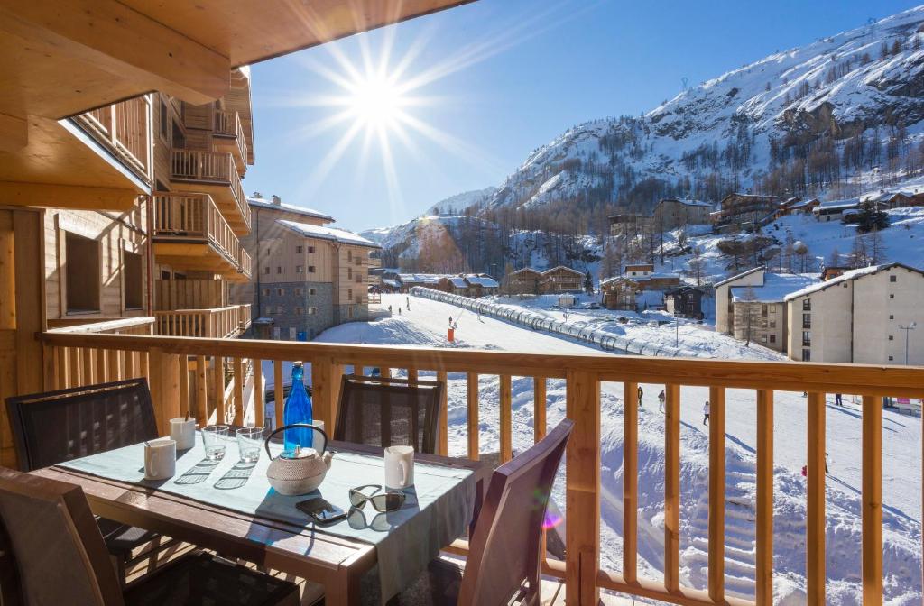a table on a balcony with a view of a mountain at Résidence Club MMV L'Altaviva in Tignes