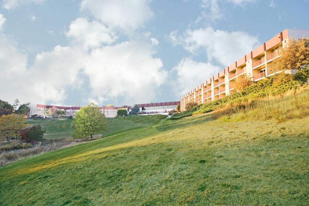 a building on a hill next to a grassy field at Red Lion Hotel Pendleton in Pendleton