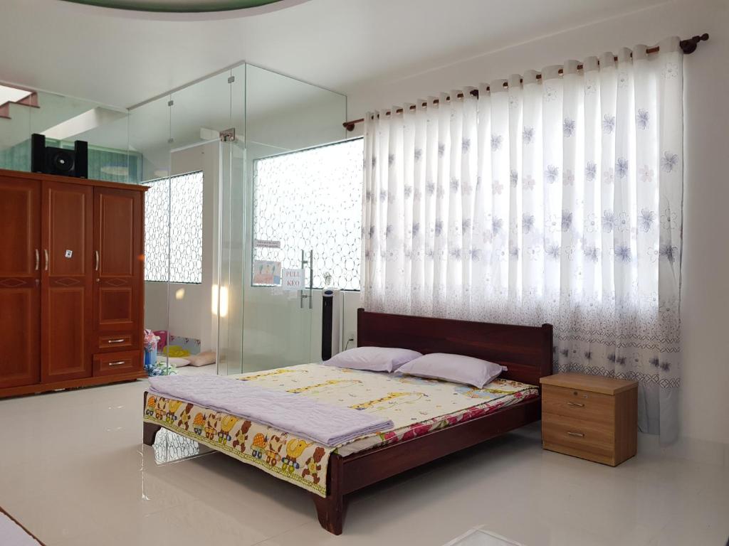 1 dormitorio con cama y ventana grande en Minh Kim Guesthouse en Ấp Phó
