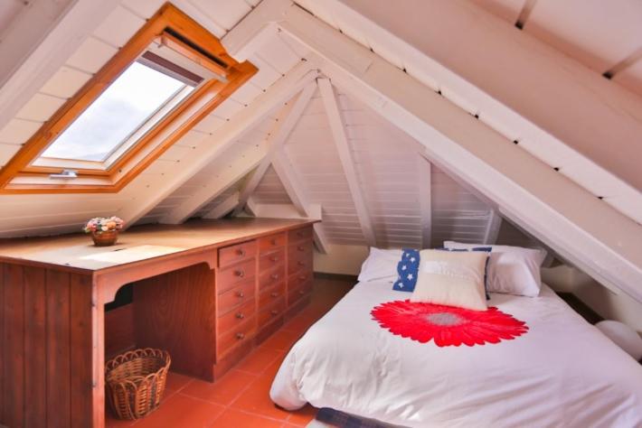 - une chambre mansardée avec un lit et une fenêtre dans l'établissement OLD TOWN PENTHOUSE - Barreirinha, à Funchal