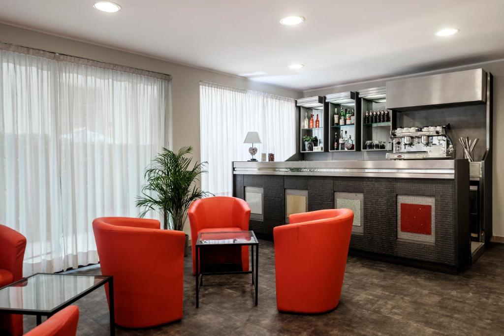 bar z pomarańczowymi krzesłami i blatem w obiekcie HOTEL CONDOR w Rimini
