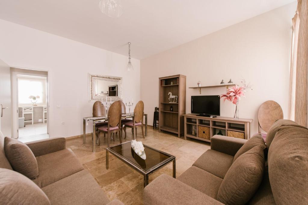 ein Wohnzimmer mit einem Sofa und einem Tisch in der Unterkunft Alameda Amor Suite by Valcambre in Sevilla