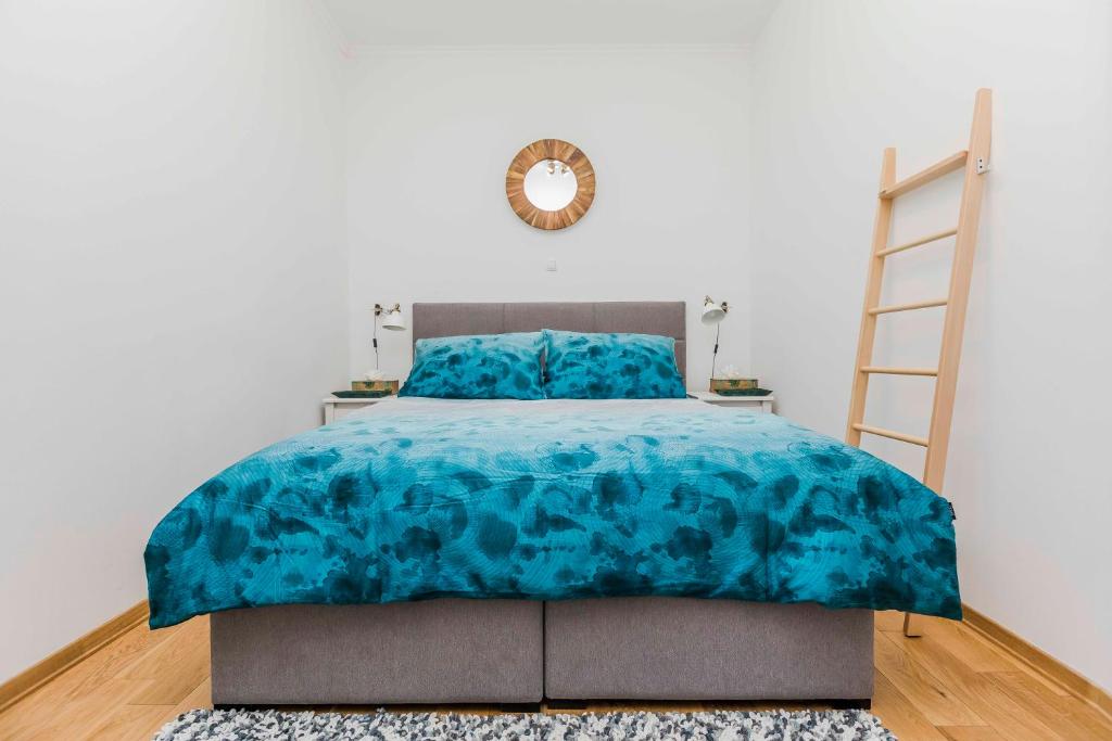 una camera da letto con un piumone blu su un letto di Apartments Horizons a Spalato (Split)