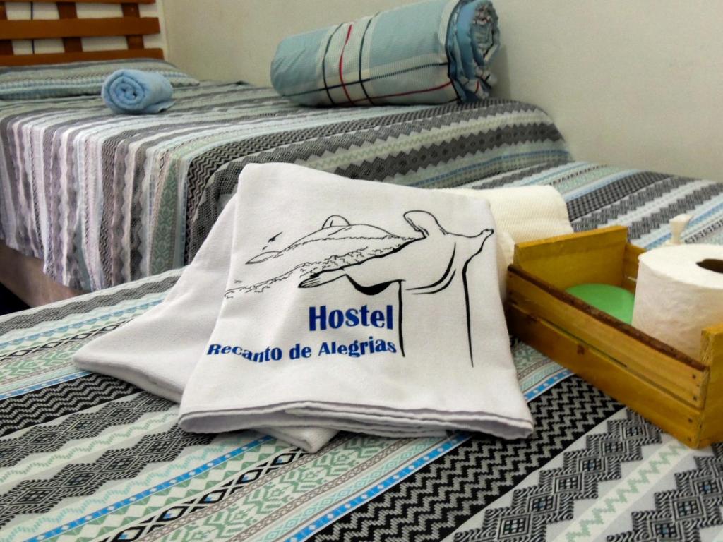 uma almofada numa cama com uma placa de hostel em Hostel Recanto de Alegrias em São Cristòvão no Rio de Janeiro