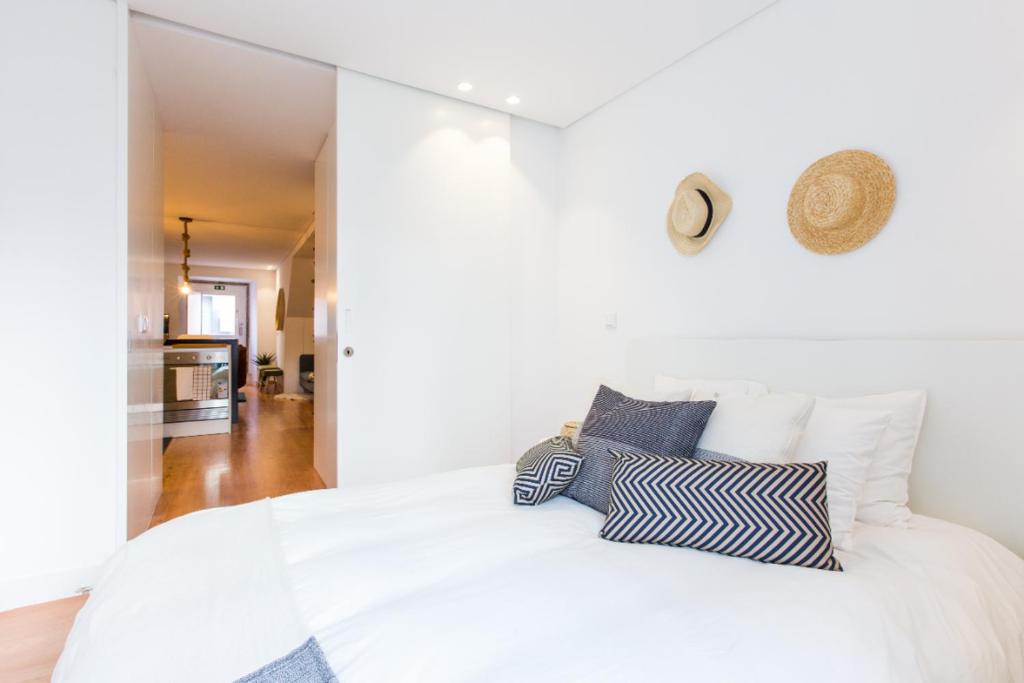 リスボンにあるSweet Spot @ Alcântaraのベッドルーム1室(白と青の枕が備わる白いベッド1台付)