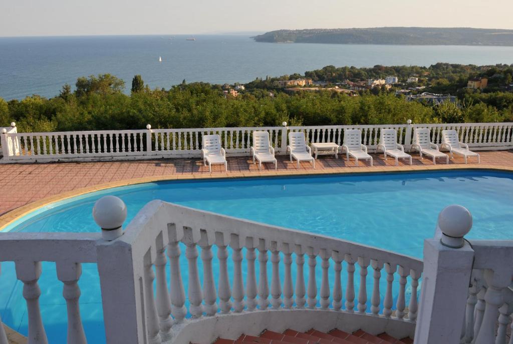 a swimming pool with chairs and a white fence at Family Hotel Casablanca Green in Varna City