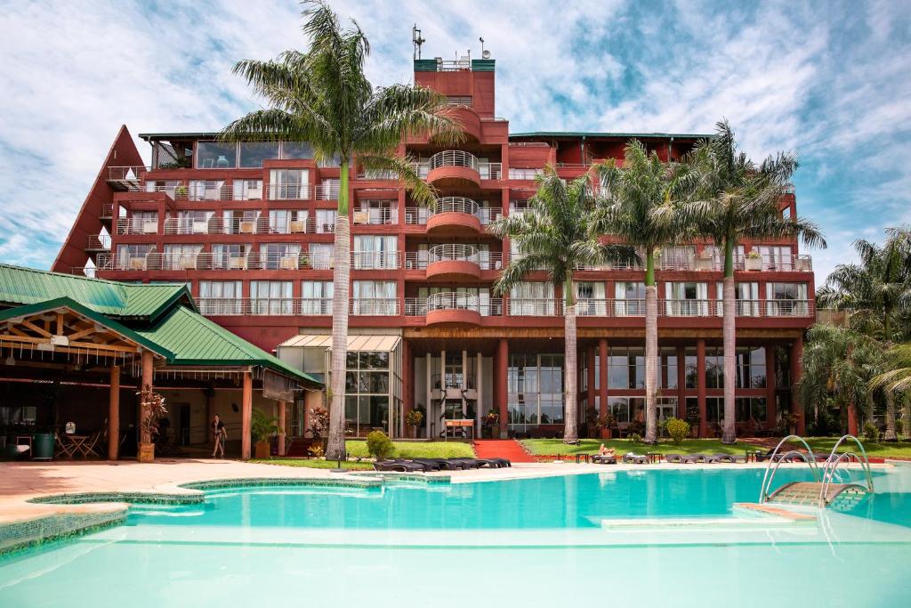 um hotel com piscina em frente a um edifício em Amérian Portal Del Iguazú Hotel em Porto Iguaçu