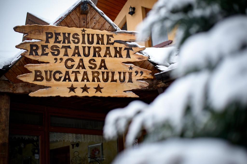a sign for a restaurant with snow on it at Casa Bucatarului in Bălnaca