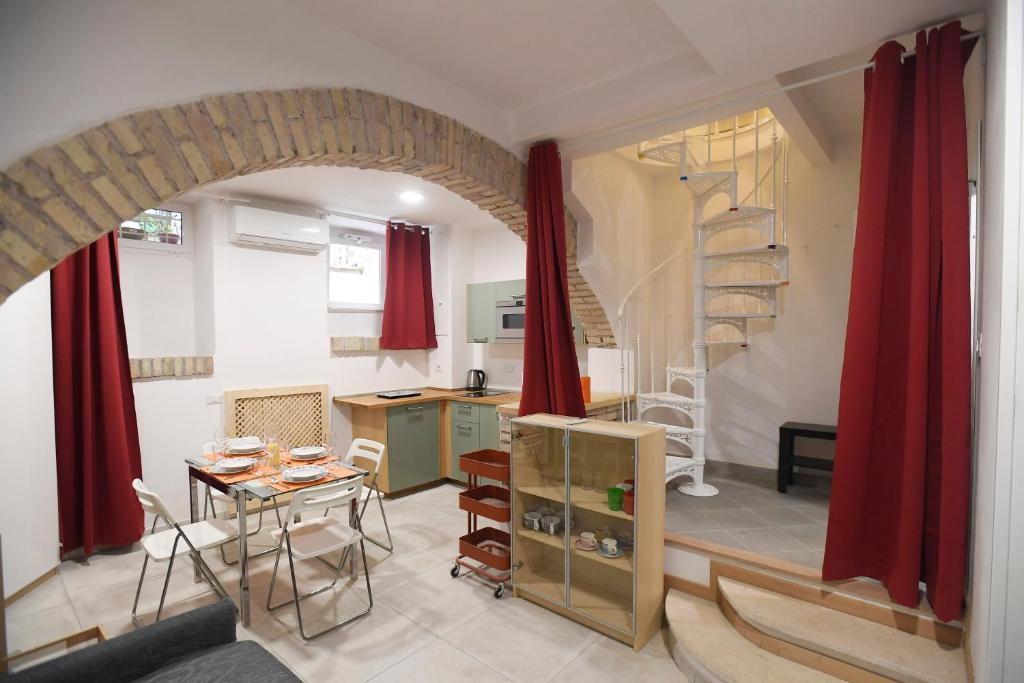 ローマにあるSanti Quattro Apartment & Rooms - Colosseoのリビングルーム(テーブル付)、螺旋階段