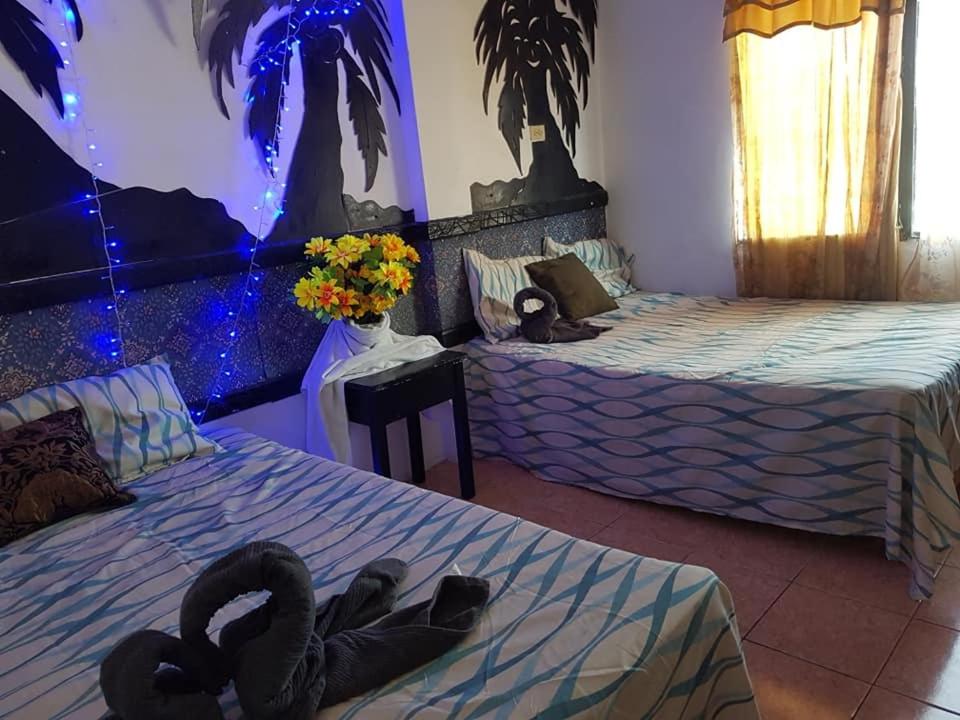 two beds in a room with two swans on them at Bachelor Inn Hotel in Belize City