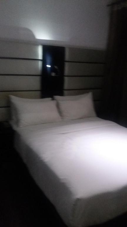 a bed with white sheets and pillows in a room at JN Sunflower in Le Morne