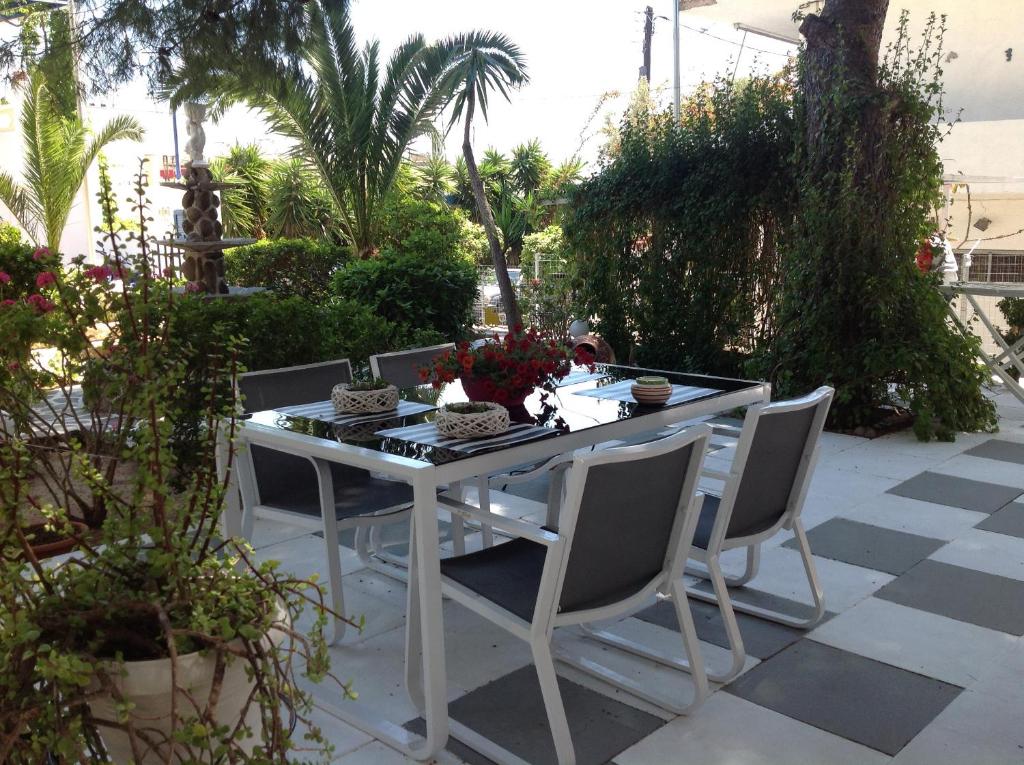 a white table and chairs on a patio at Angela Hotel in Agia Marina Aegina