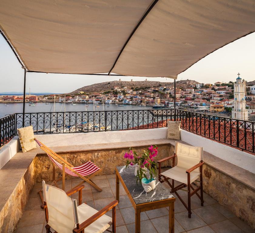 a balcony with chairs and a table with a view at Rosalia Apartments in Halki