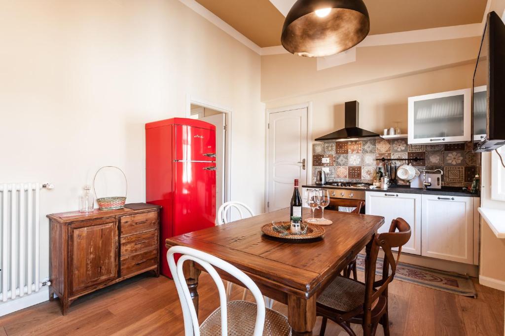 cocina con mesa de madera y nevera roja en Affordable suite with a view in the Heart of Lucca, en Lucca
