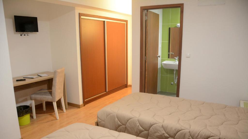 a bedroom with a bed and a desk and a sink at BELO CAMPO - Ilha do Faial (Horta) in Castelo Branco