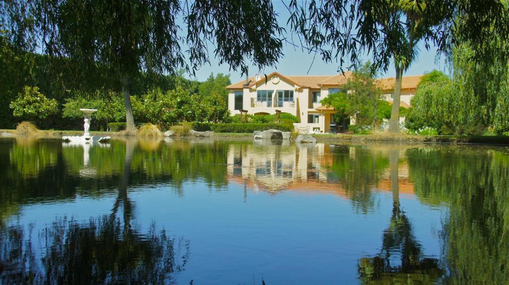 a house with a pond in front of a house at Tuscany Downs Estate in Darfield