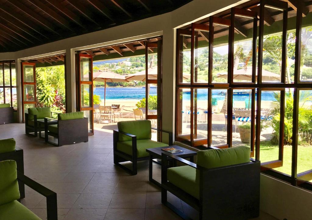 a lobby with chairs and a view of the water at Young Island Resort in Kingstown