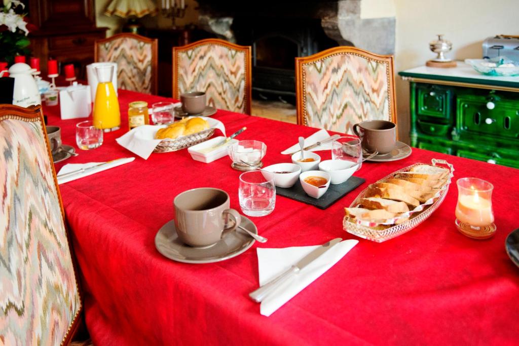 a table with a red table cloth with food on it at Chambres d&#39;hôtes les Etoiles in Mareugheol