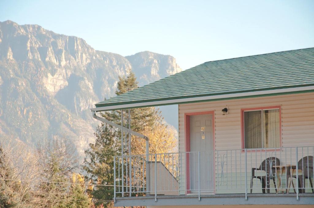 a house with a balcony with mountains in the background at Sunset Motel in Creston
