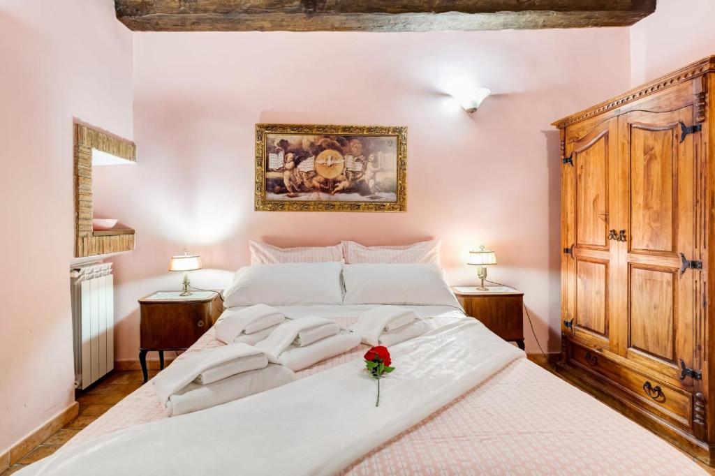 Un dormitorio con una gran cama blanca con flores. en Colosseum Rione Monti 1, en Roma